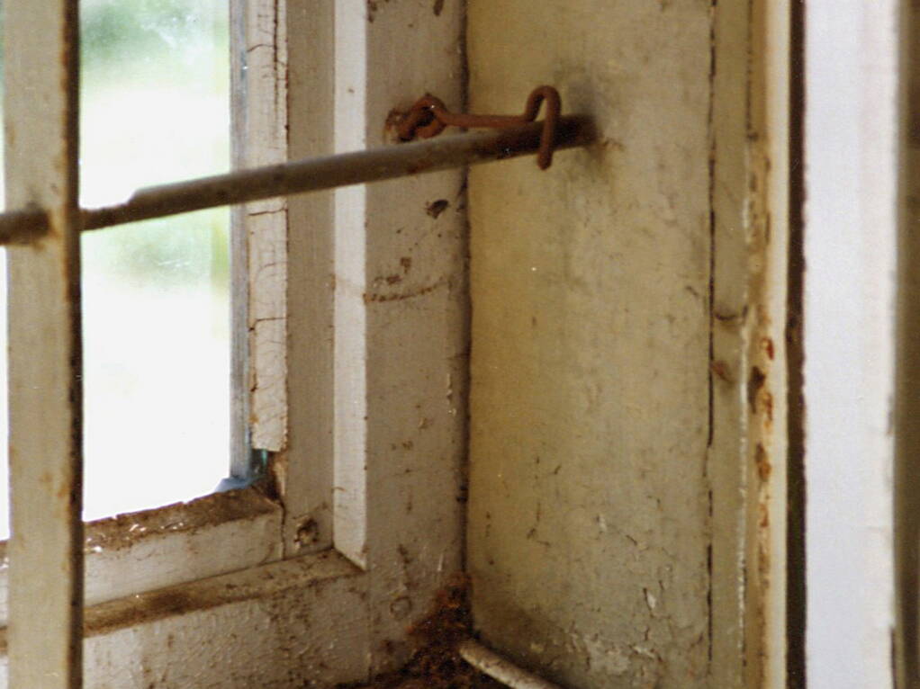 Ein altes Fenster im Erdgeschoss mit dem davor eingehängten Vorfenster. Das Metallgitter schützte das ehemali­gen Telegraphenbüro vor Neugierigen. 